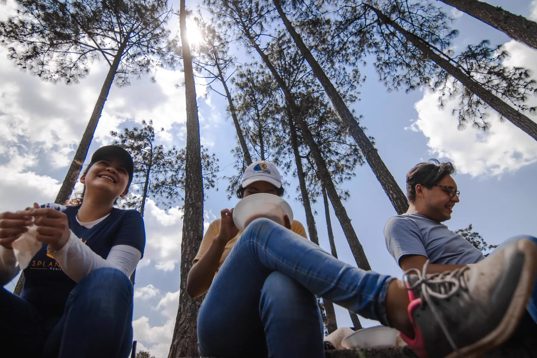 Equipo de jóvenes de GYC descansando entre los pinos durante una jornada de misión