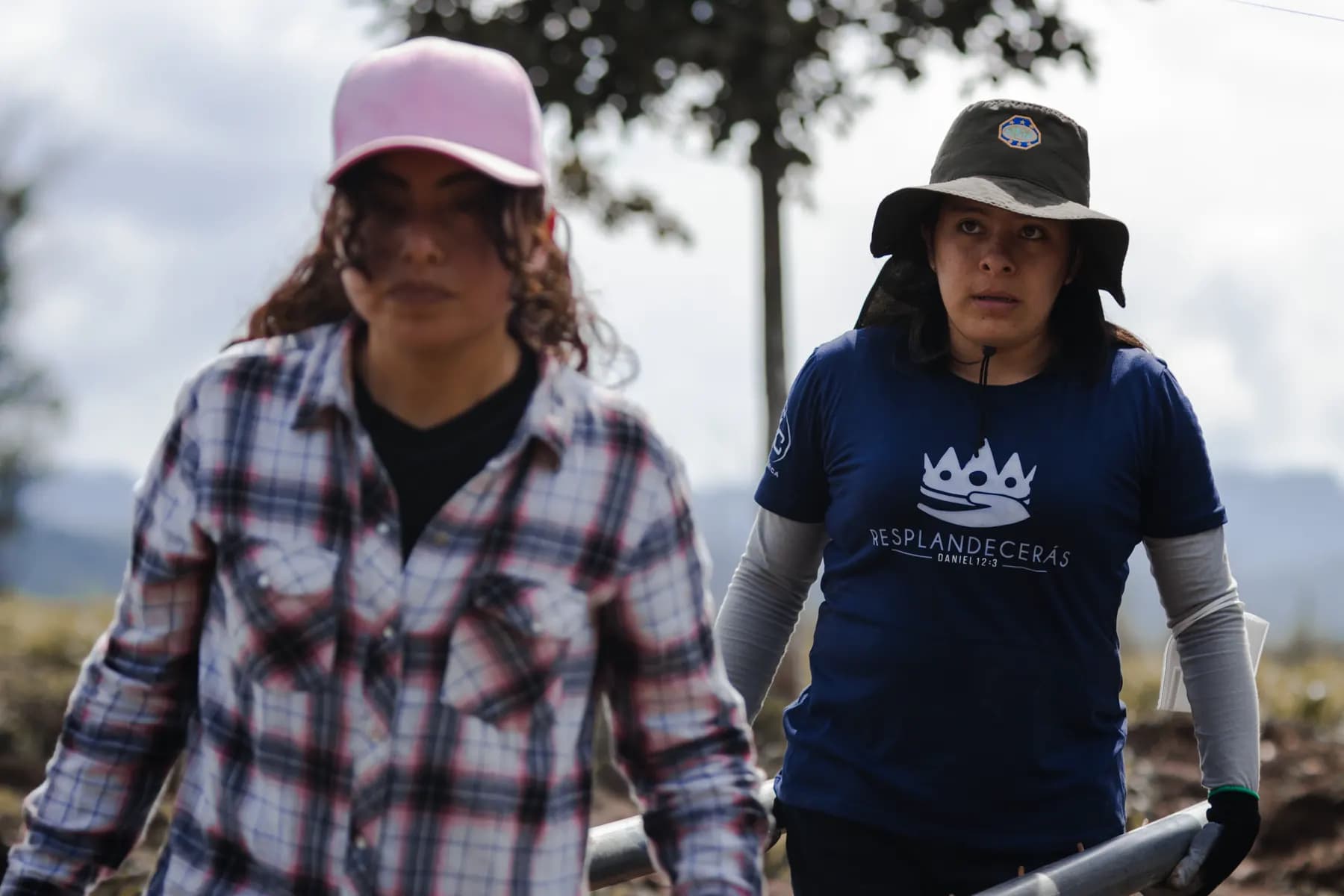 Dos voluntarias de GYC cargando materiales en el campo