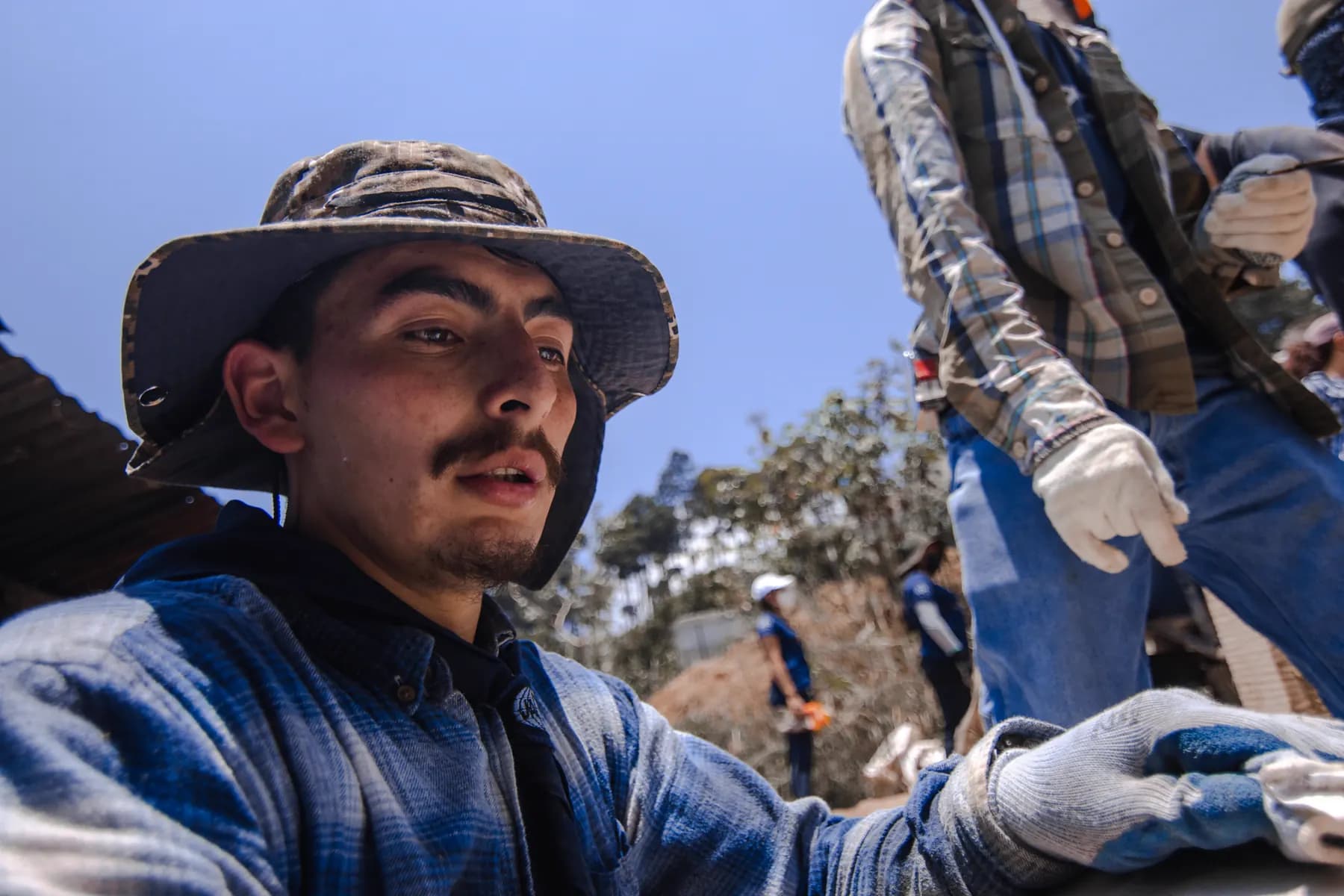 Un joven de GYC trabajando con guantes durante una jornada de servicio
